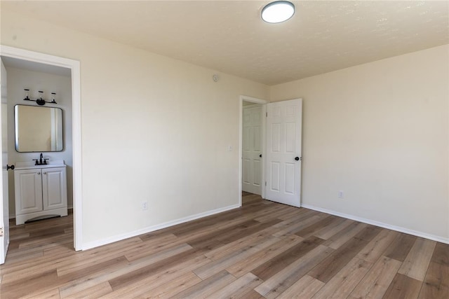 empty room with light wood-type flooring and sink