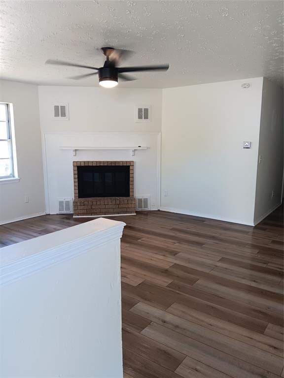 2916 SW 61st St, Oklahoma City, OK 73159 - unfurnished living room with dark wood-type flooring, a textured ceiling, and visible vents