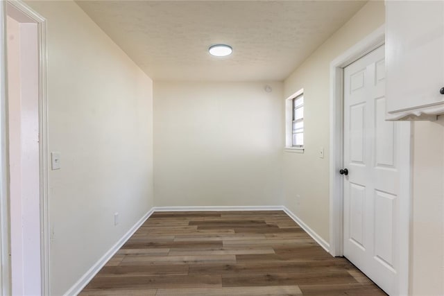 2916 SW 61st St, Oklahoma City, OK 73159 - hallway featuring a textured ceiling, baseboards, and wood finished floors