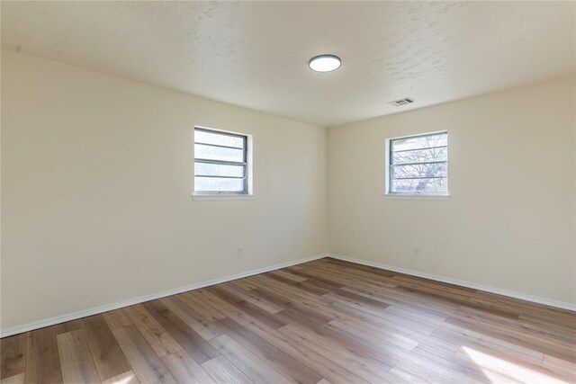 2916 SW 61st St, Oklahoma City, OK 73159 - empty room with baseboards, wood finished floors, a wealth of natural light, and visible vents
