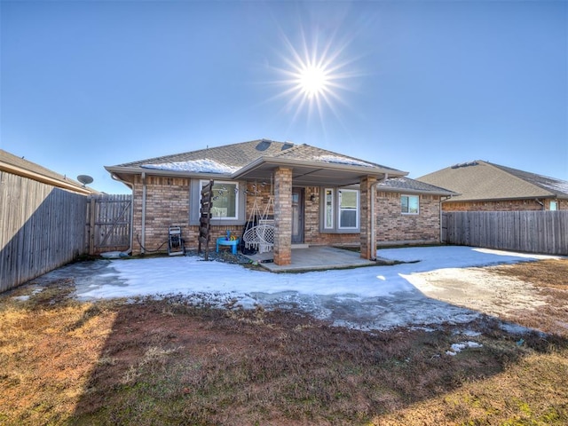 rear view of property with a patio area, brick siding, and a fenced backyard