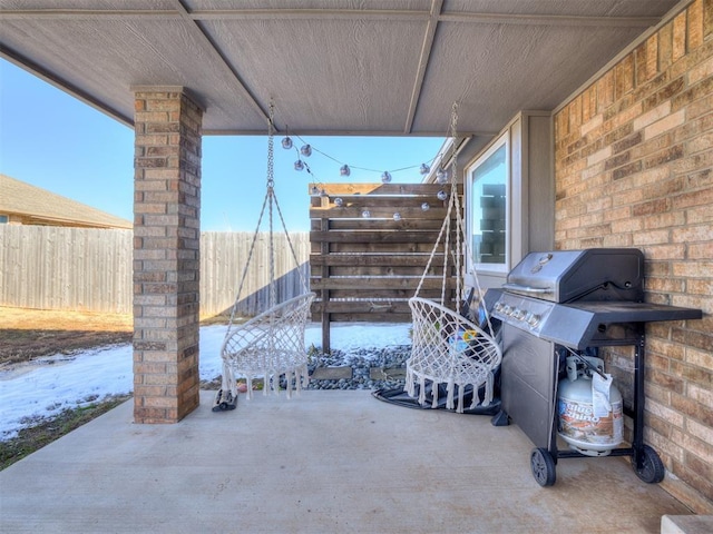 view of patio featuring a grill and fence