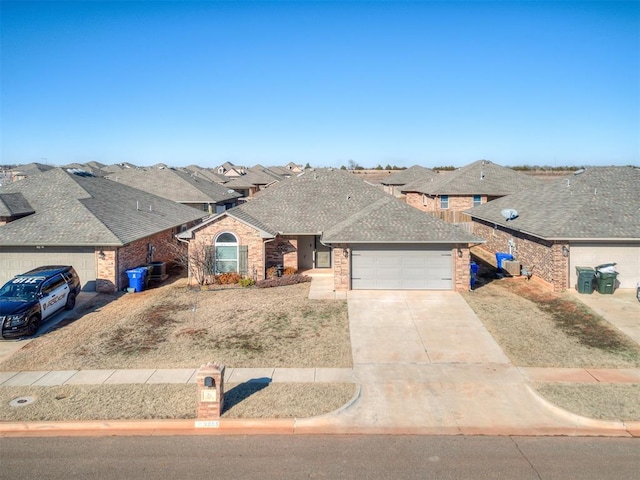 view of front of home with concrete driveway, a shingled roof, an attached garage, and brick siding