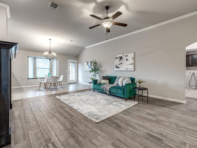 unfurnished living room featuring lofted ceiling, visible vents, ornamental molding, wood finished floors, and baseboards