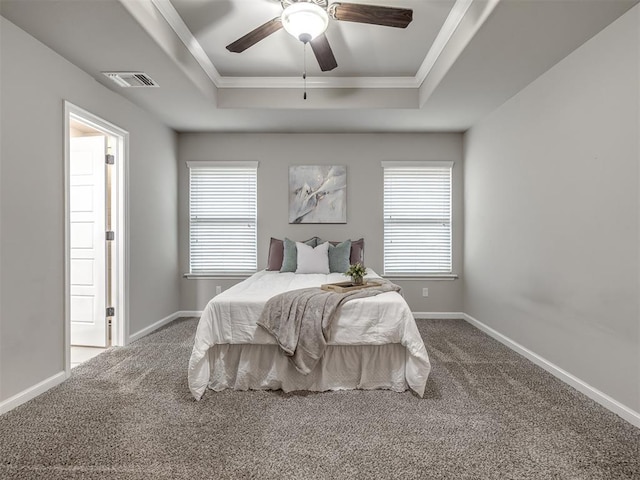 bedroom with multiple windows, visible vents, and a raised ceiling