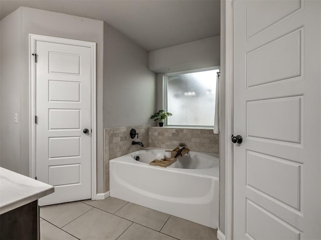 bathroom with a garden tub, vanity, and tile patterned floors