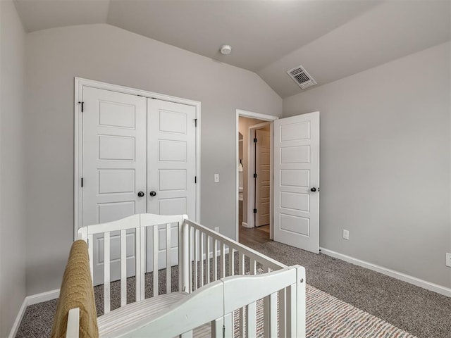 carpeted bedroom featuring vaulted ceiling, a closet, visible vents, and baseboards