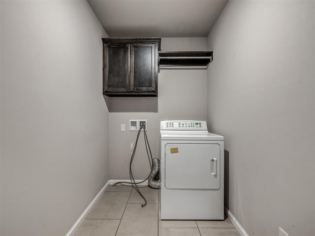 laundry room featuring washer / dryer, light tile patterned floors, baseboards, and cabinet space