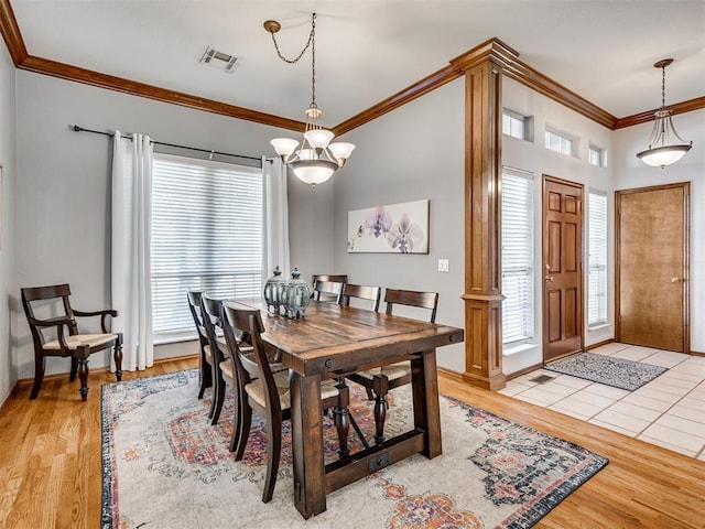 dining space featuring crown molding, light hardwood / wood-style floors, a chandelier, and a healthy amount of sunlight