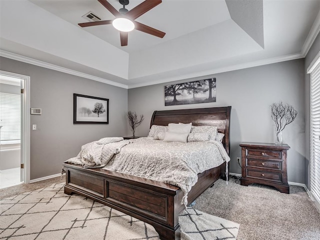 carpeted bedroom with ceiling fan, a raised ceiling, and multiple windows