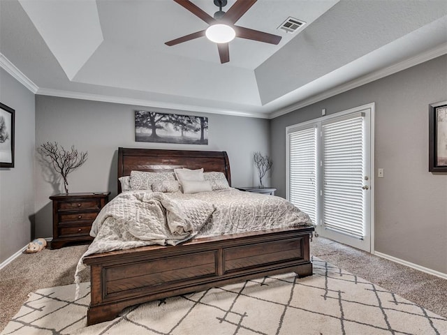 bedroom featuring a raised ceiling, light carpet, and ceiling fan