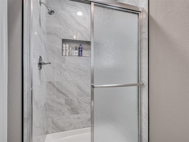 bathroom with a shower with door