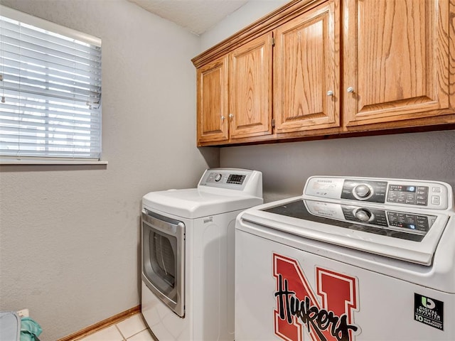 laundry area with cabinets, washer and dryer, and light tile patterned floors