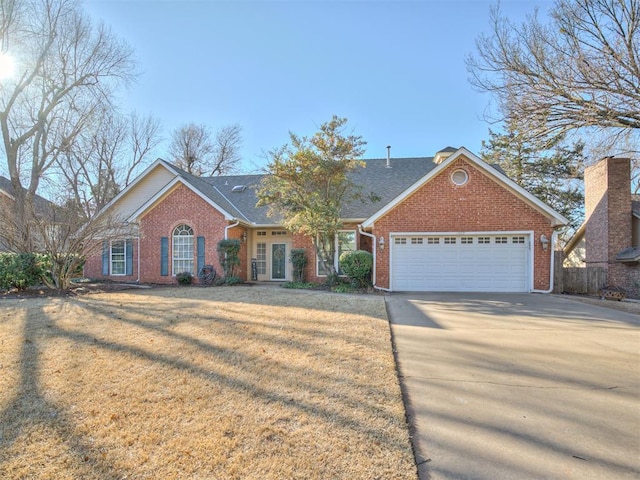 view of front facade with a garage, a front yard, concrete driveway, and brick siding