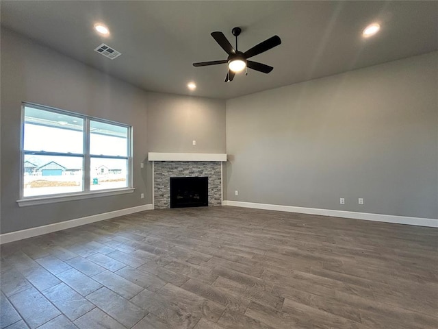 unfurnished living room featuring recessed lighting, visible vents, a ceiling fan, a stone fireplace, and baseboards