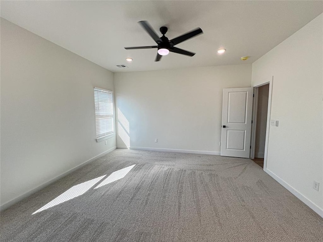 spare room with ceiling fan and light colored carpet