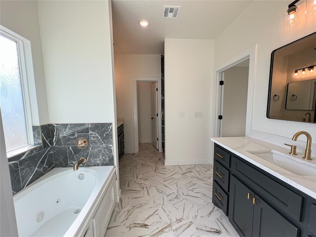 bathroom featuring vanity, a healthy amount of sunlight, and a tub