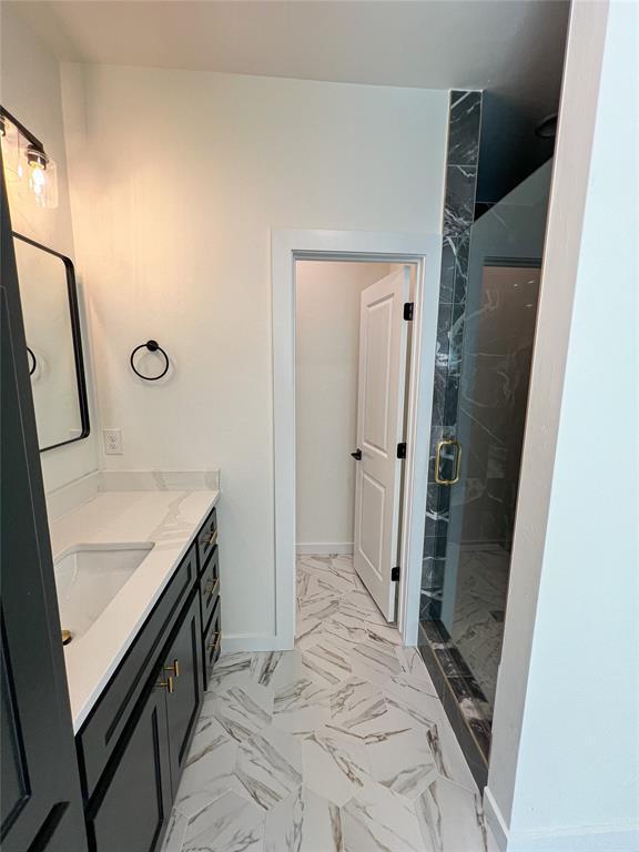 bathroom with vanity and a shower with door