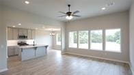 kitchen featuring a center island with sink, ceiling fan, and light hardwood / wood-style flooring