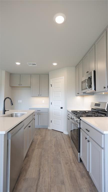 kitchen featuring a center island, stainless steel appliances, light hardwood / wood-style flooring, and sink