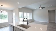 kitchen featuring pendant lighting, dishwasher, sink, and ceiling fan with notable chandelier