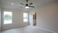 carpeted spare room with ceiling fan