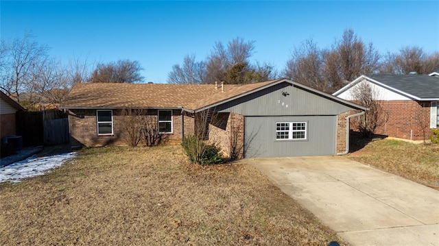 ranch-style house featuring central air condition unit, a front yard, and a garage