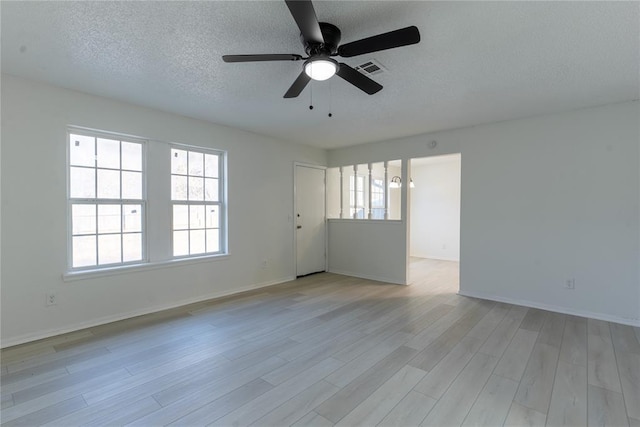 empty room featuring light hardwood / wood-style floors, a textured ceiling, and ceiling fan