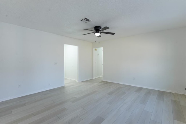 unfurnished room with ceiling fan, a textured ceiling, and light wood-type flooring