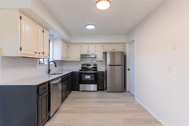 kitchen with light hardwood / wood-style floors, sink, stainless steel appliances, and tasteful backsplash