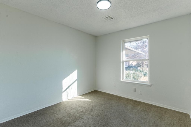 unfurnished room with a textured ceiling and carpet floors