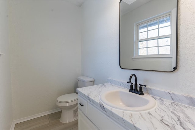 bathroom featuring vanity, hardwood / wood-style flooring, and toilet