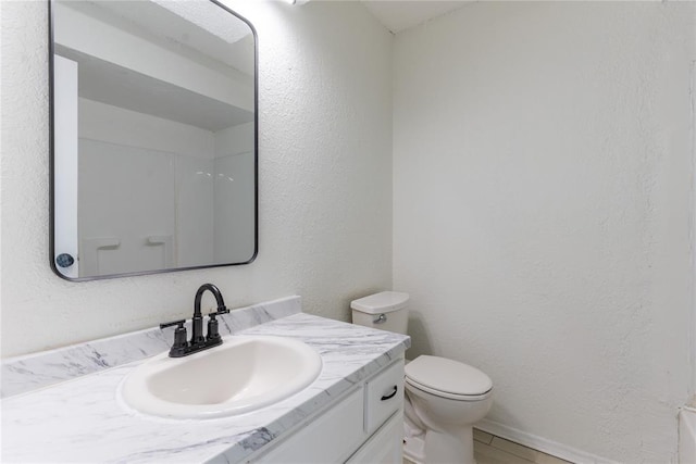 bathroom with tile patterned floors, toilet, vanity, and walk in shower