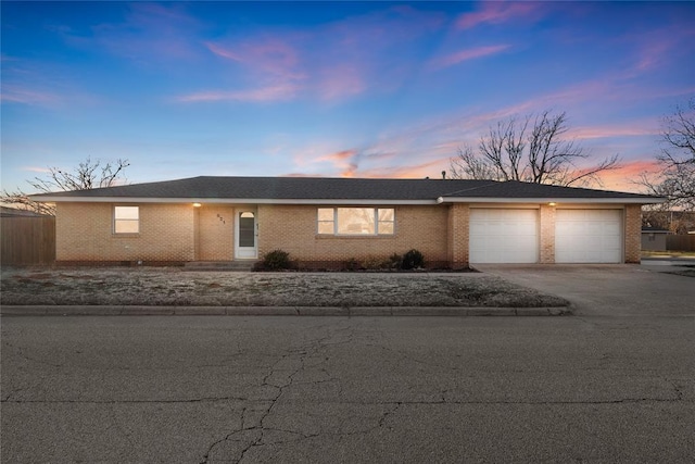 ranch-style home with brick siding, concrete driveway, and a garage