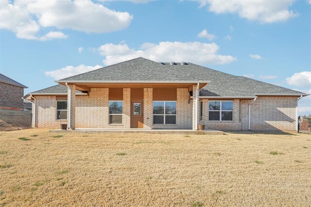 rear view of house featuring a lawn