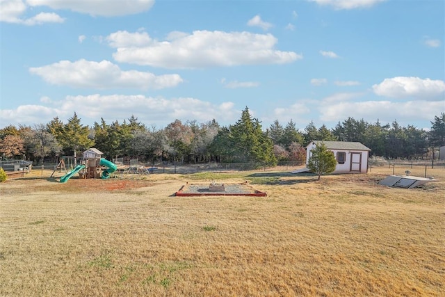 view of jungle gym featuring a lawn and a storage unit