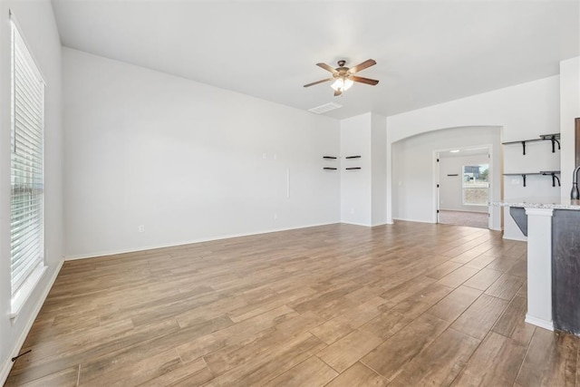 unfurnished living room featuring ceiling fan and light wood-type flooring