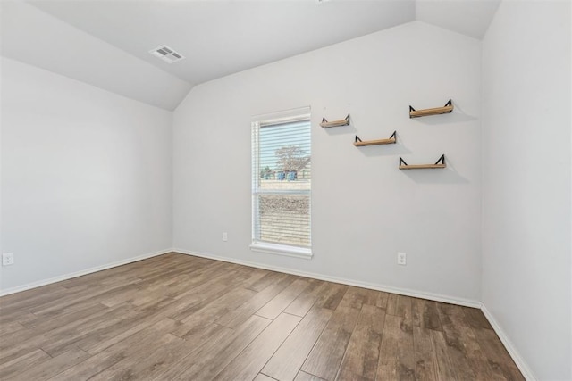 empty room featuring lofted ceiling and light wood-type flooring