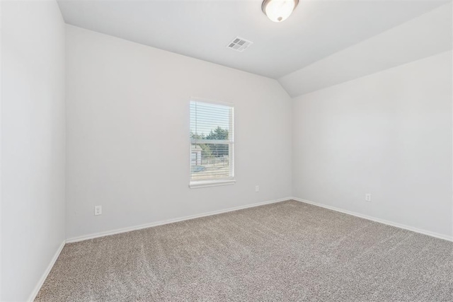 empty room featuring carpet floors and vaulted ceiling