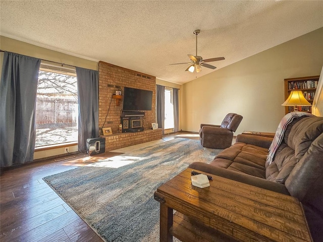 living room featuring dark wood-type flooring, a wood stove, a textured ceiling, and lofted ceiling