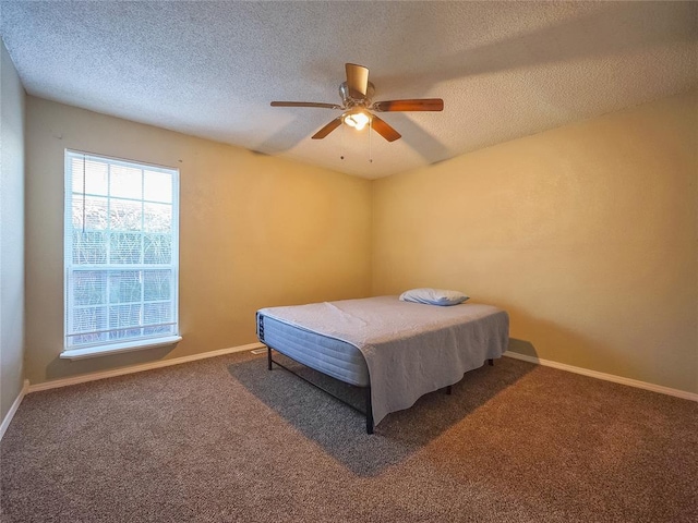 carpeted bedroom with ceiling fan and a textured ceiling