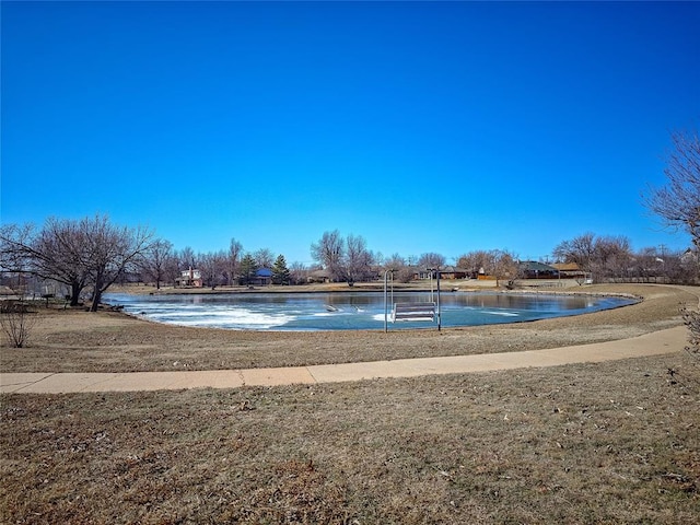 view of swimming pool with a lawn and a water view