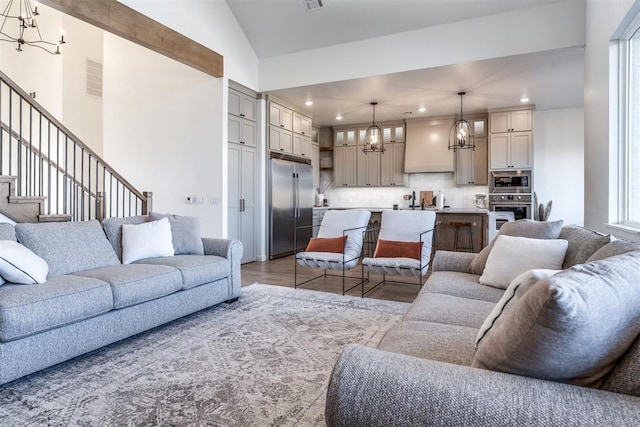 living room featuring a notable chandelier and vaulted ceiling