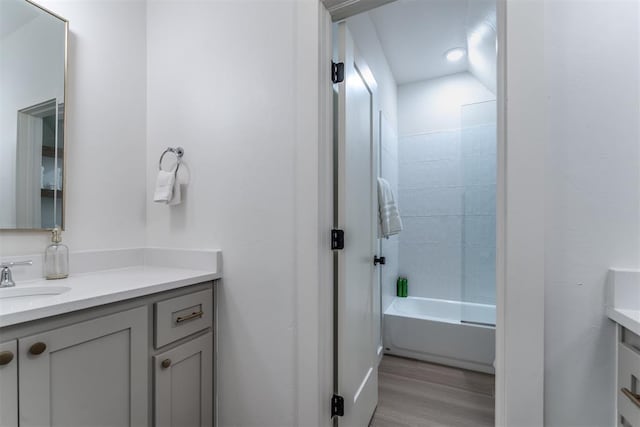 bathroom featuring hardwood / wood-style floors, vanity, and shower / washtub combination