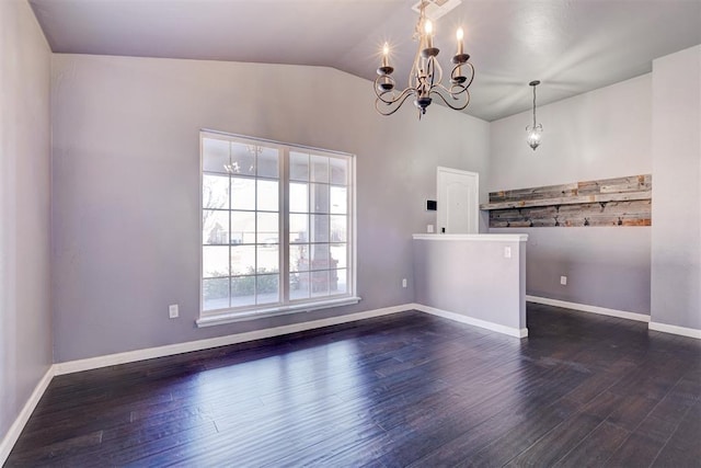 empty room featuring an inviting chandelier, lofted ceiling, and dark hardwood / wood-style floors