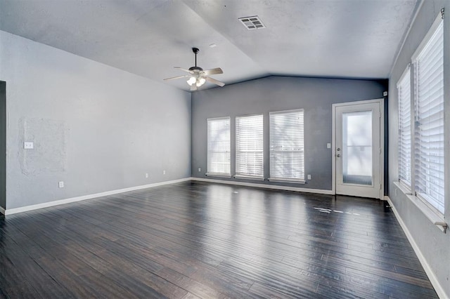 spare room with lofted ceiling, ceiling fan, a wealth of natural light, and dark hardwood / wood-style floors