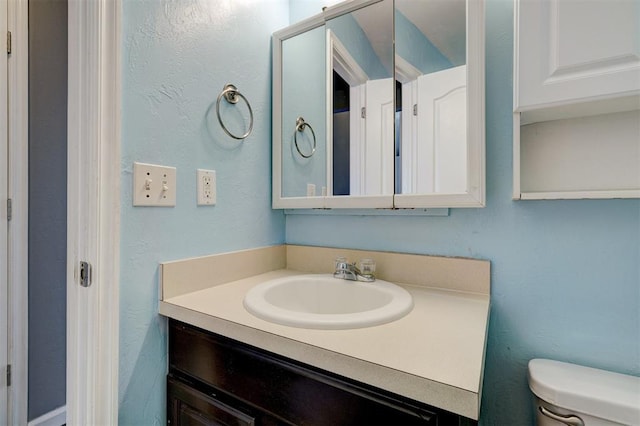 bathroom featuring toilet and vanity