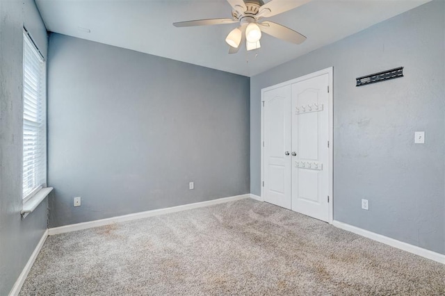 empty room featuring ceiling fan and carpet flooring