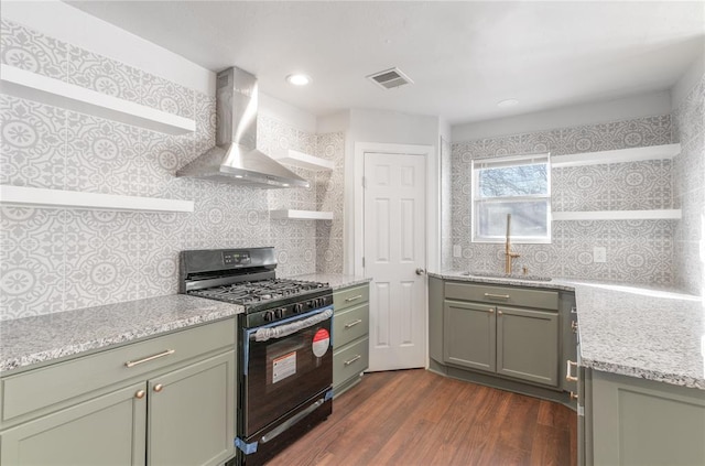 kitchen featuring sink, wall chimney range hood, tasteful backsplash, dark hardwood / wood-style floors, and black gas stove