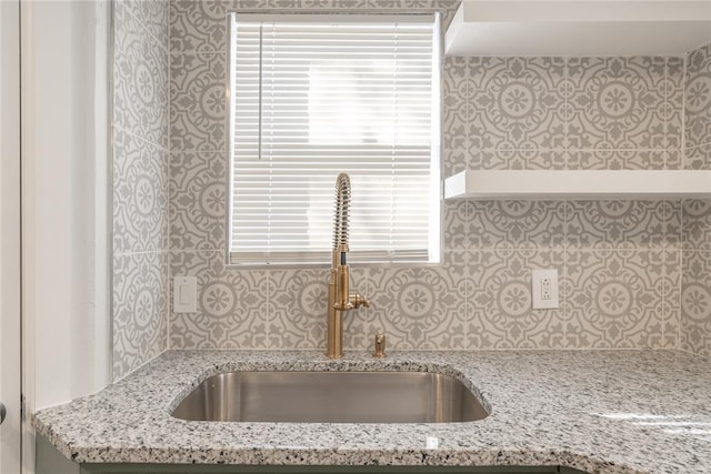 kitchen with light stone countertops and sink